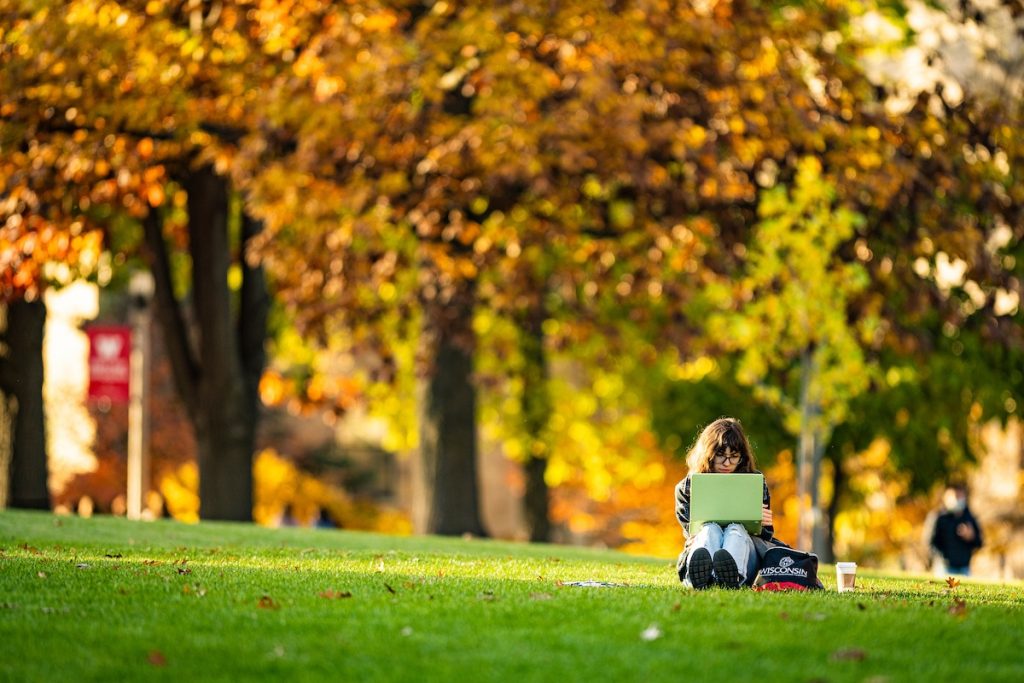 A UW student enjoys a warm day while studying among the colors of the fall leaves on Bascom Hill at the University of Wisconsin-Madison during autumn on November 9, 2021. (Photo by Bryce Richter / UW-Madison)